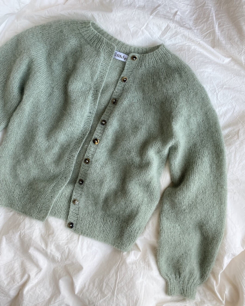 Liggebillede af lysegrøn Novice Cardigan – Mohair Edition