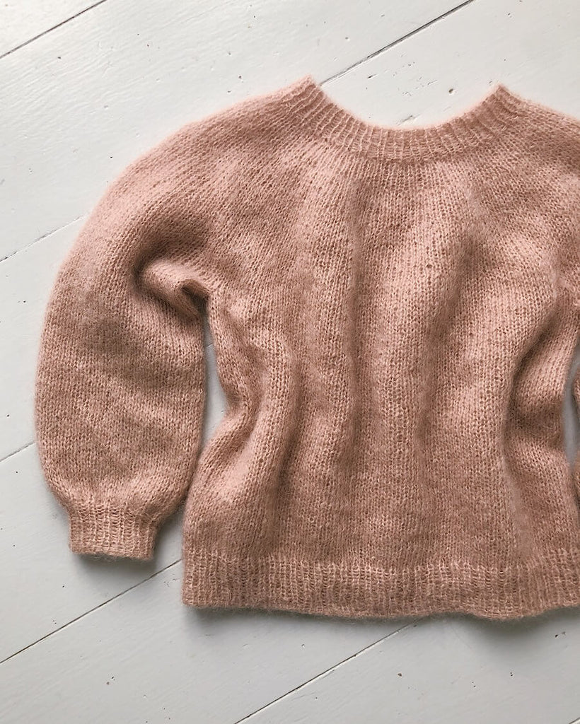 Liggebillede af lyserød Novice Sweater Junior – Mohair Edition