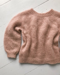 Liggebillede af lyserød Novice Sweater Junior – Mohair Edition