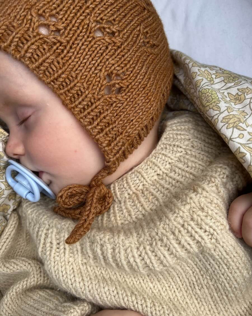 Baby iført brun Rigmors Kyse