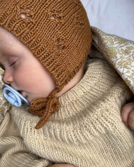 Baby iført brun Rigmors Kyse