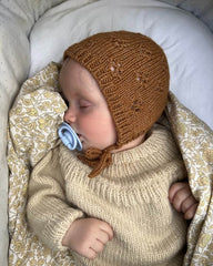 Baby iført brun Rigmors Kyse