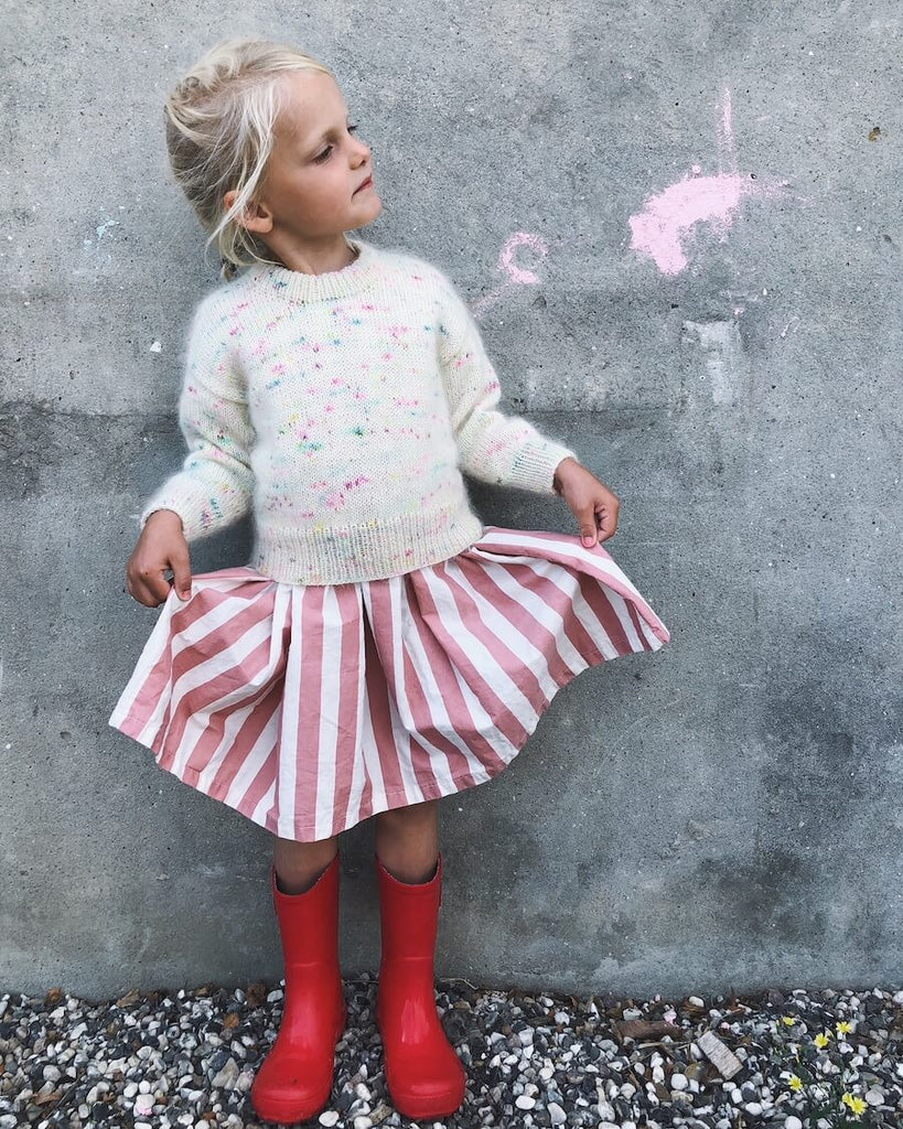 Pige iført hvid Stockholm Sweater Junior med multifarvede nistre