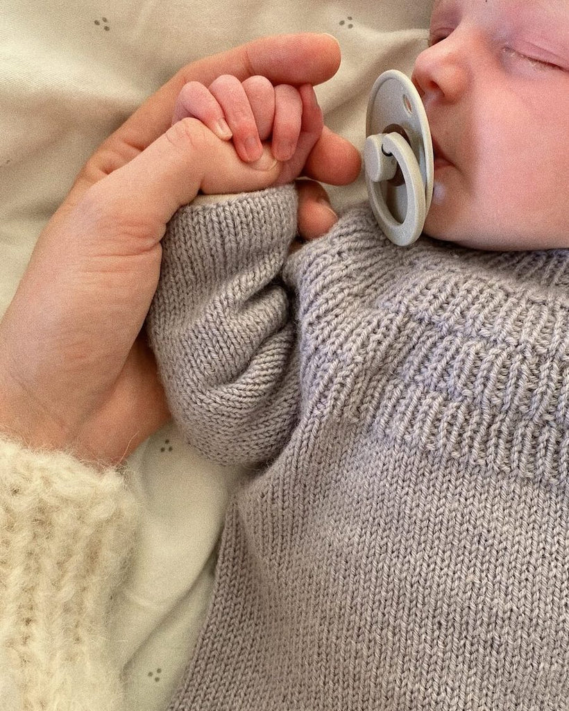 Closeup af liggende barn i lilla Ankers Bluse