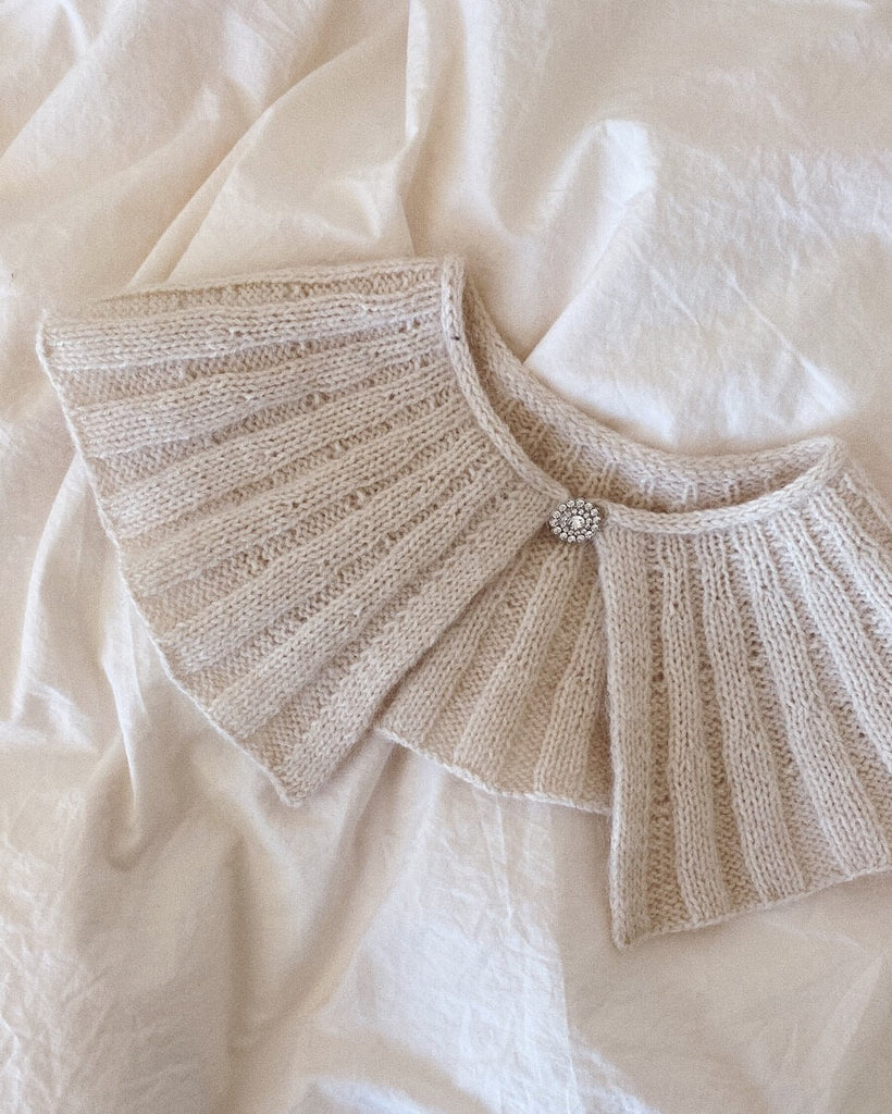 Hvid Sunday Collar liggende på dyne