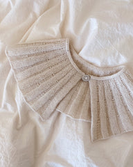 Hvid Sunday Collar liggende på dyne