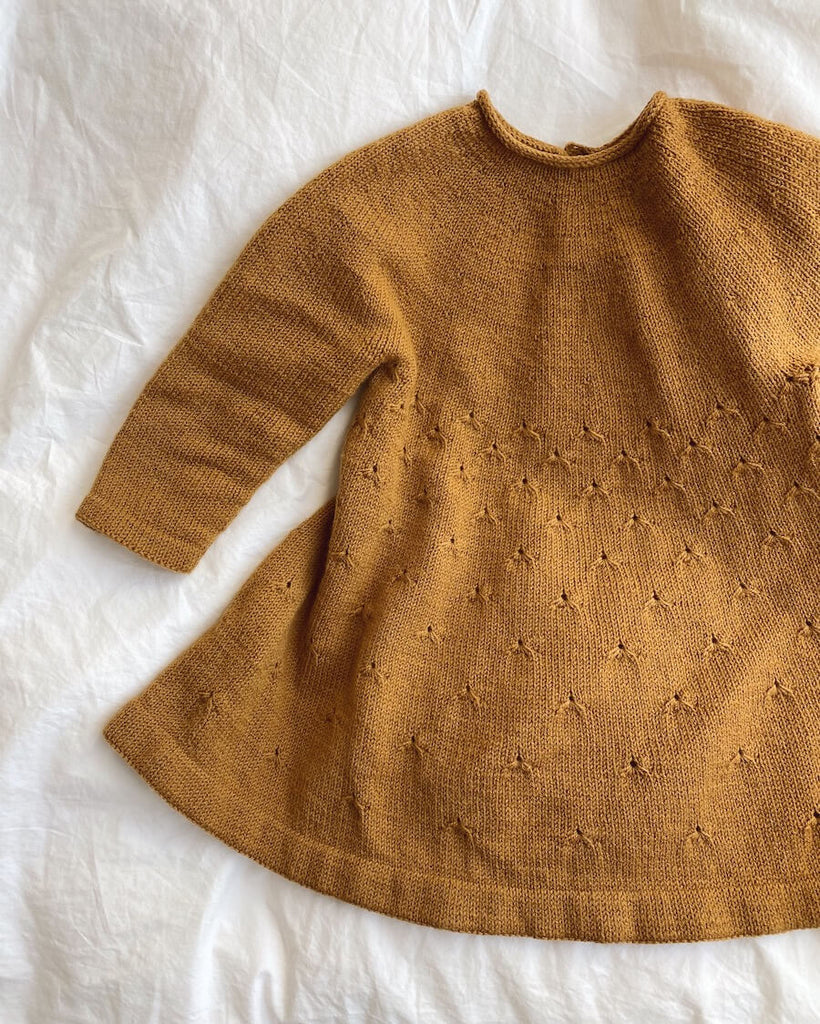 Liggebillede af okkerfarvet Mælkebøttekjole