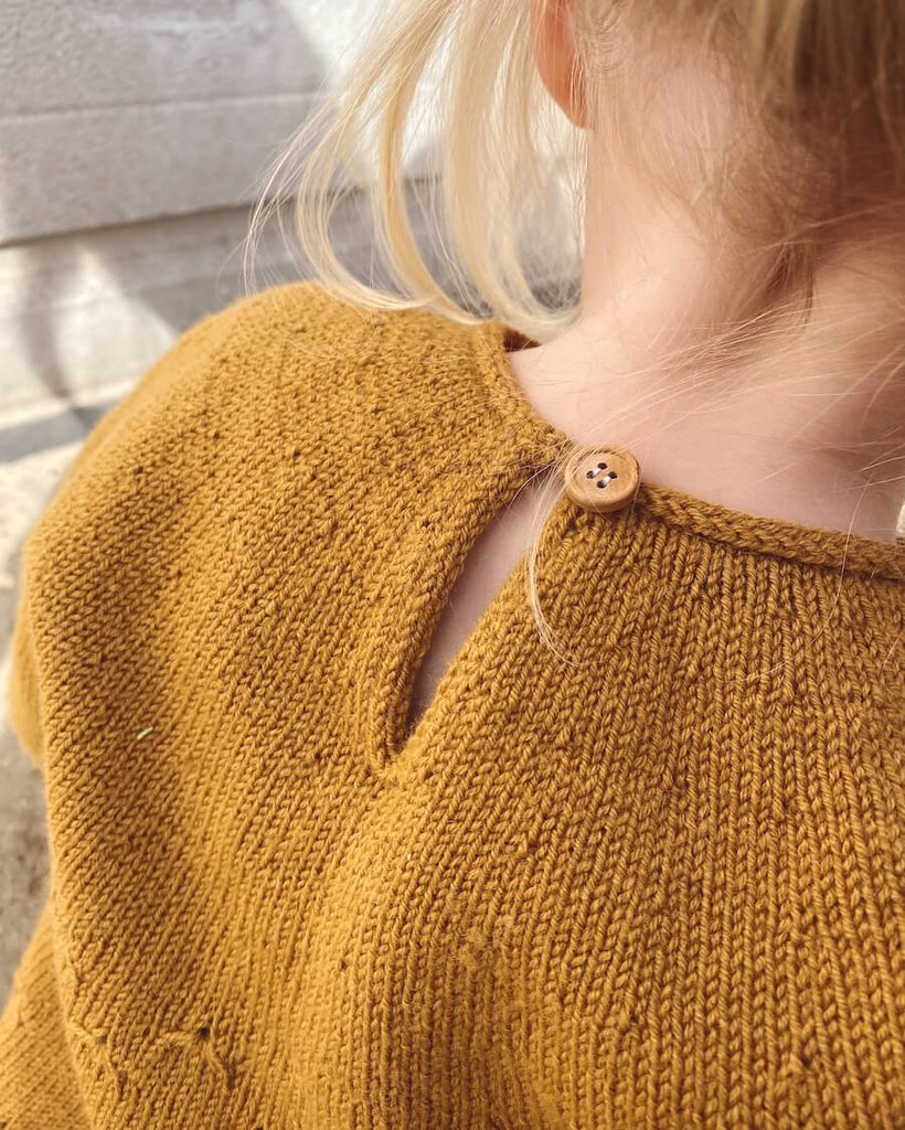 Detaljebillede af okkerfarvet Mælkebøttekjole