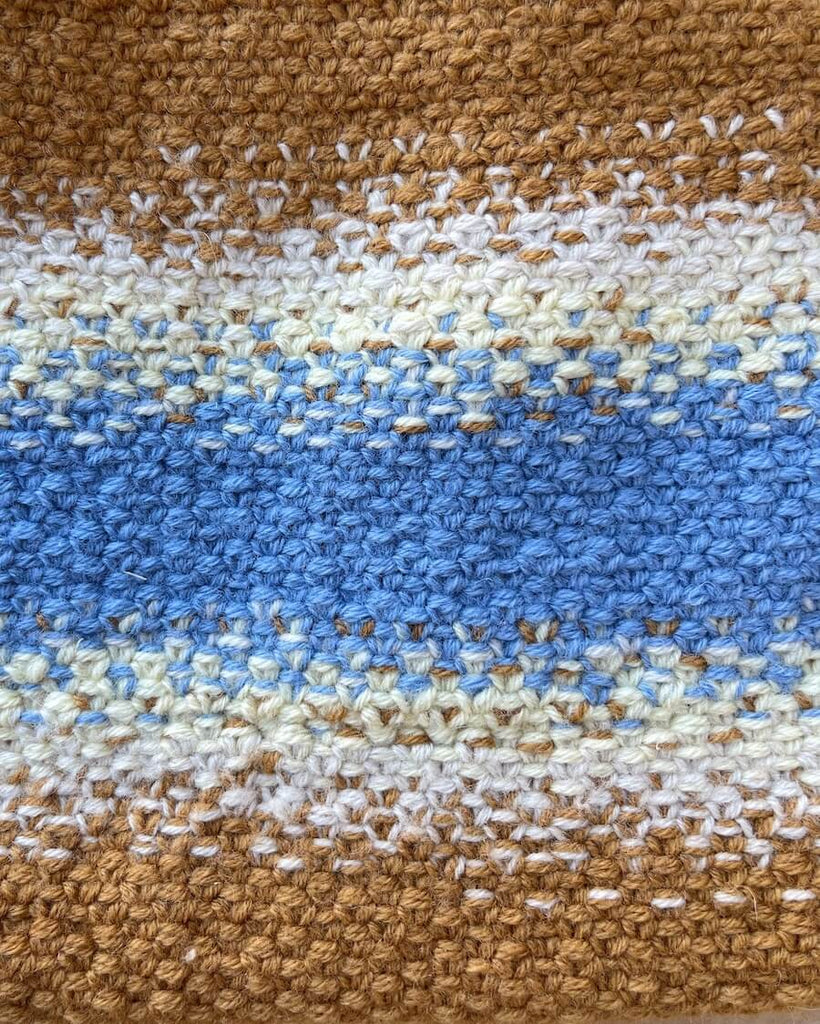 Struktur på Technicolor Purse i blå og brunlige nuancer