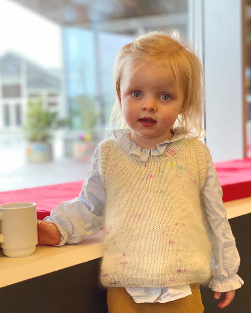 Lille pige iført hvid Stockholm Slipover Mini med multifarvede nistre