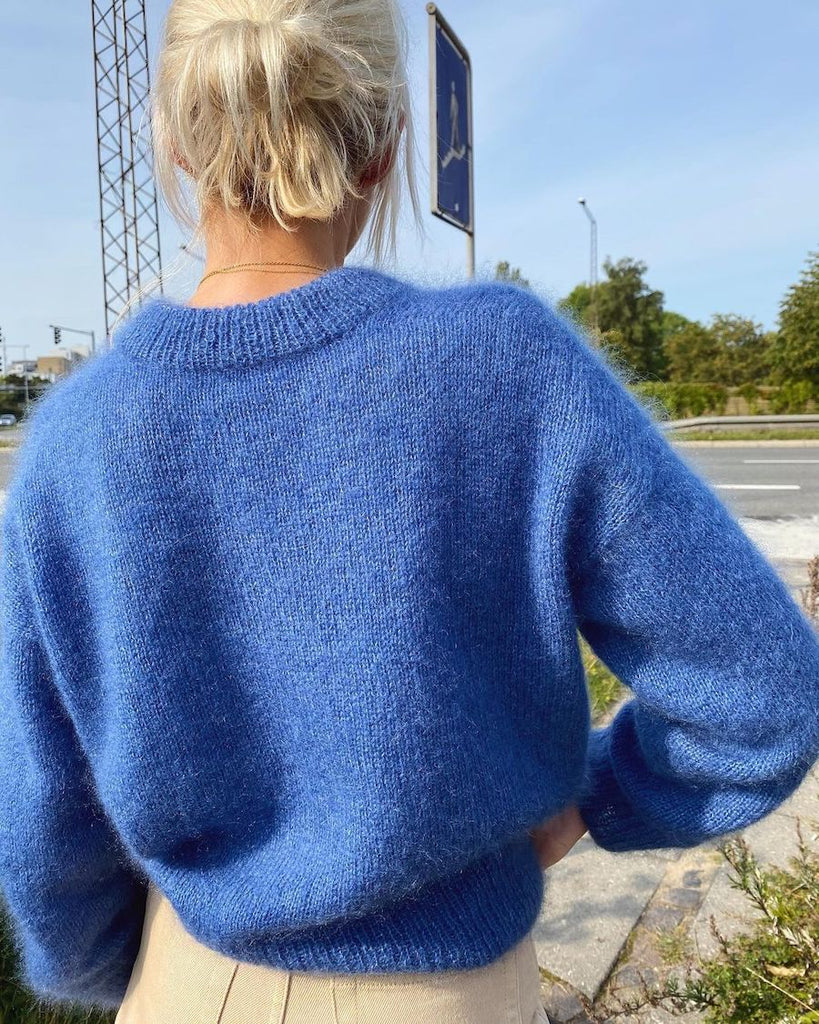 Kvinde iført blå Stockholm Sweater V-neck set fra ryggen