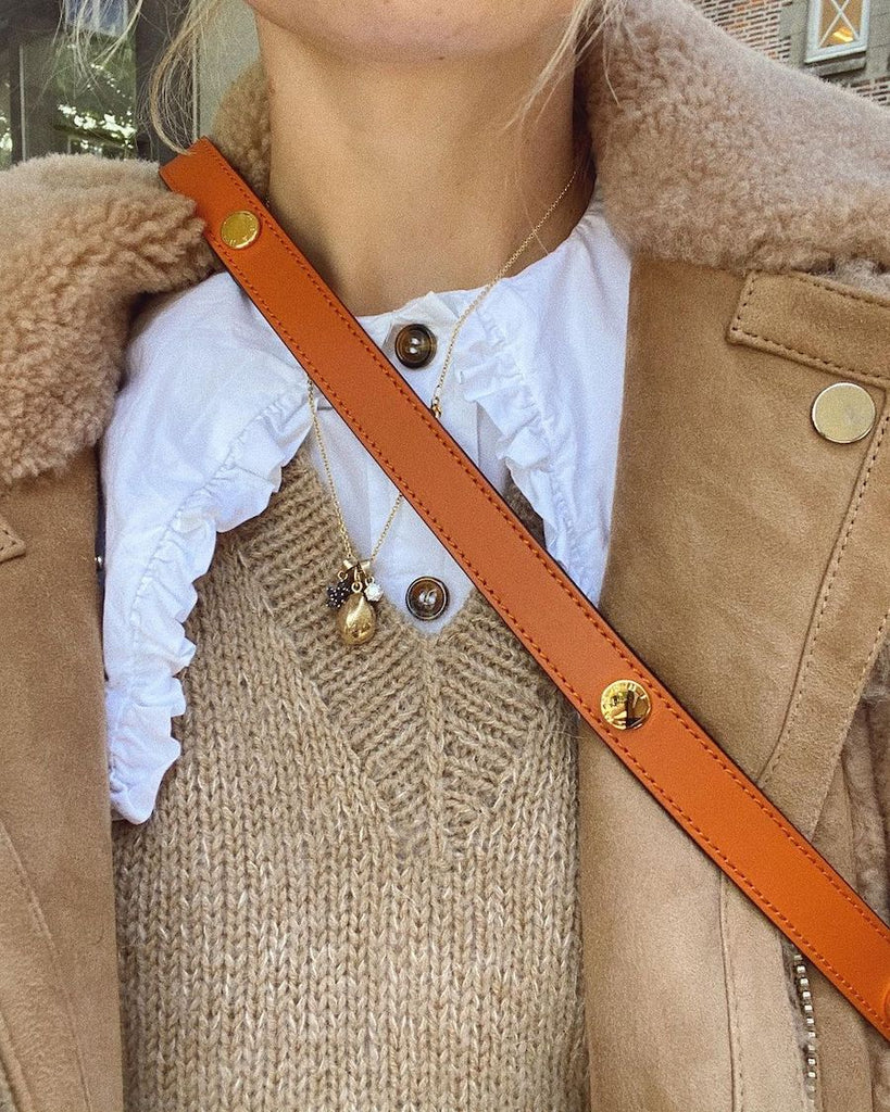 Detaljebillede af kvinde iført beige Stockholm Slipover V-neck