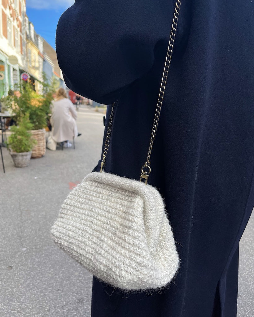 Lysegrå Winter Clutch hængende over skulderen på kvinde