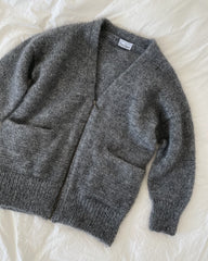 Grå Zipper Jacket liggende på dyne