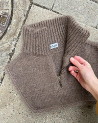 Brun Zipper Neck liggende på flise