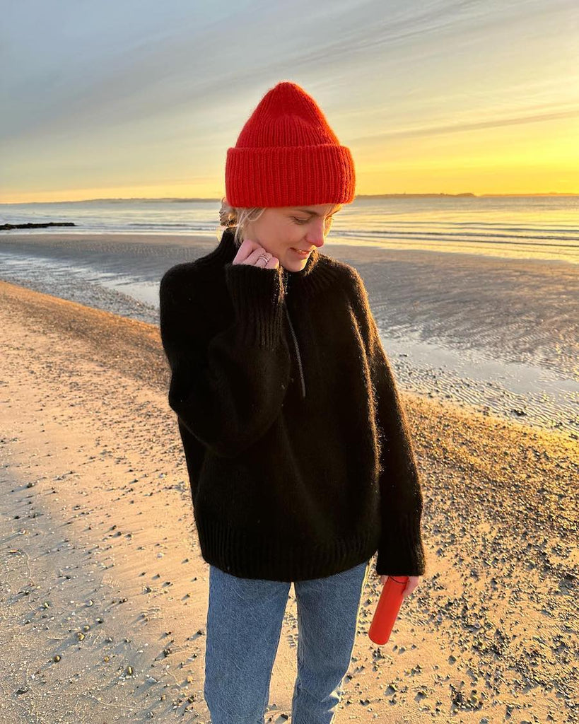 Kvinde iført sort Zipper Sweater på strand