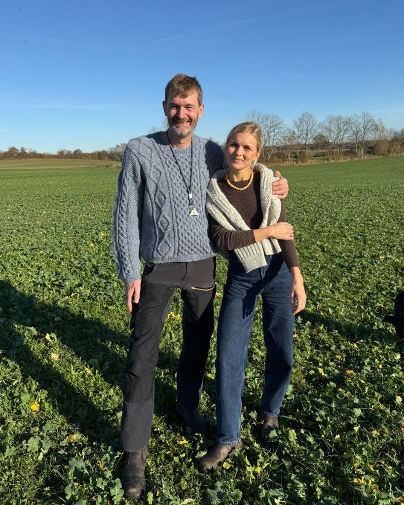 Mand iført blå Dagmar Sweater Man stående sammen med kvinde med Ingrid Sweater over skuldrene