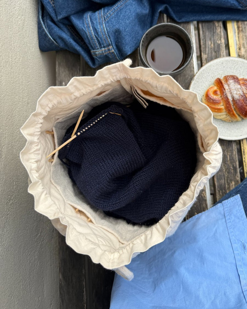 Knitter's Project Bag i farven Cloud stående på cafébænk set oppefra
