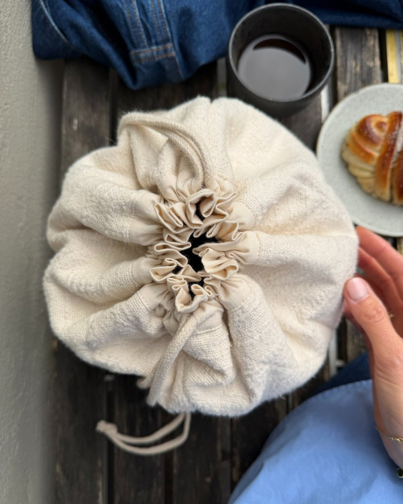 Knitter's Project Bag i farven Cloud stående på cafébænk set oppefra
