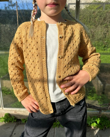 Barn iført gul Annas Sommercardigan