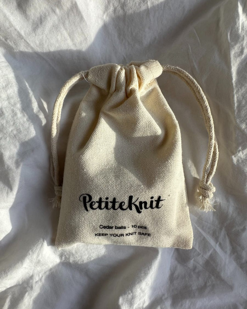 Stofpose med petiteknit logo på, indeholdende cedertræskugler
