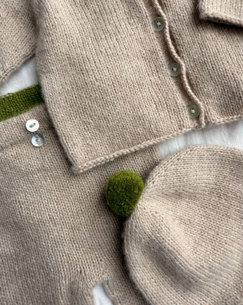 Closeup af beige Cleo Baby Set med grønne detaljer