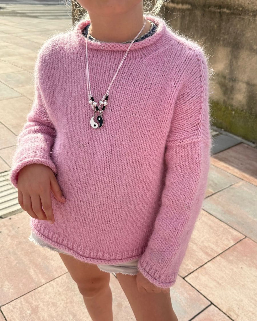 Barn iført lyserød Cloud Sweater Junior