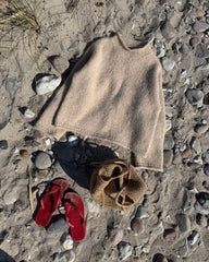 Beige Cloud Sweater liggende på stranden