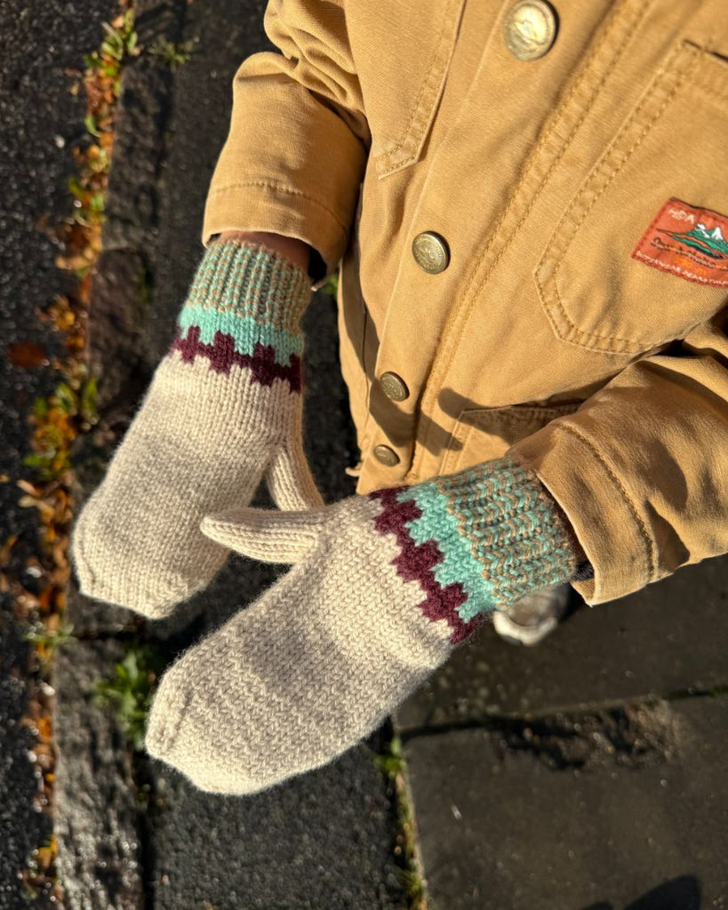 Barn iført vanterne fra beige og turkis Cross Set