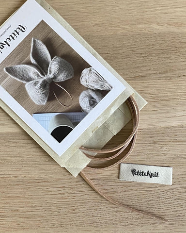 Læderhank til December bow i posemed postkort og petiteknit label