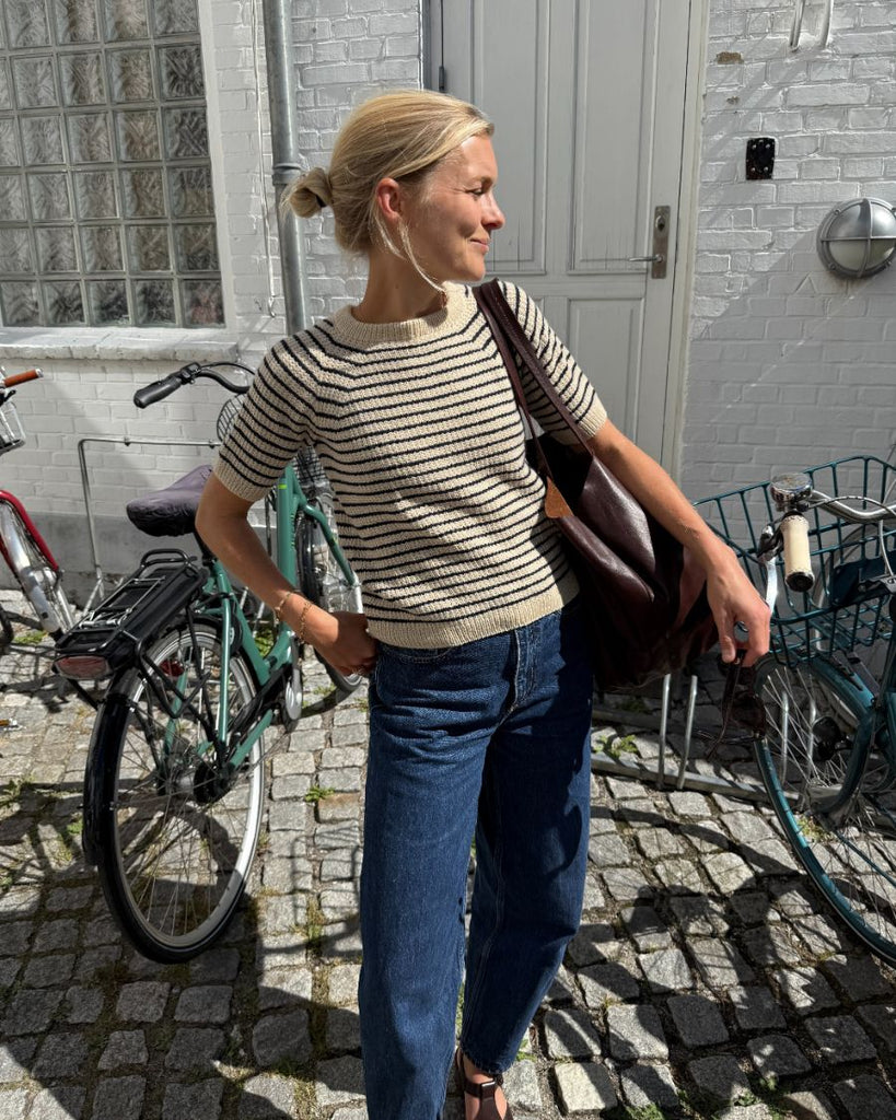 Kvinde iført hvid og blå Friday Tee