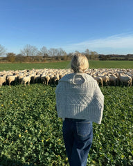 Kvinde med lysegrå Ingrid Sweater over skuldrene set bagfra
