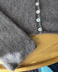 Detaljer ved knapstolpen på mørkelilla Ivy Cardigan 