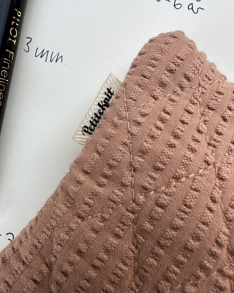 Nærbillede af praline purse i seersucker stof med petiteknit label