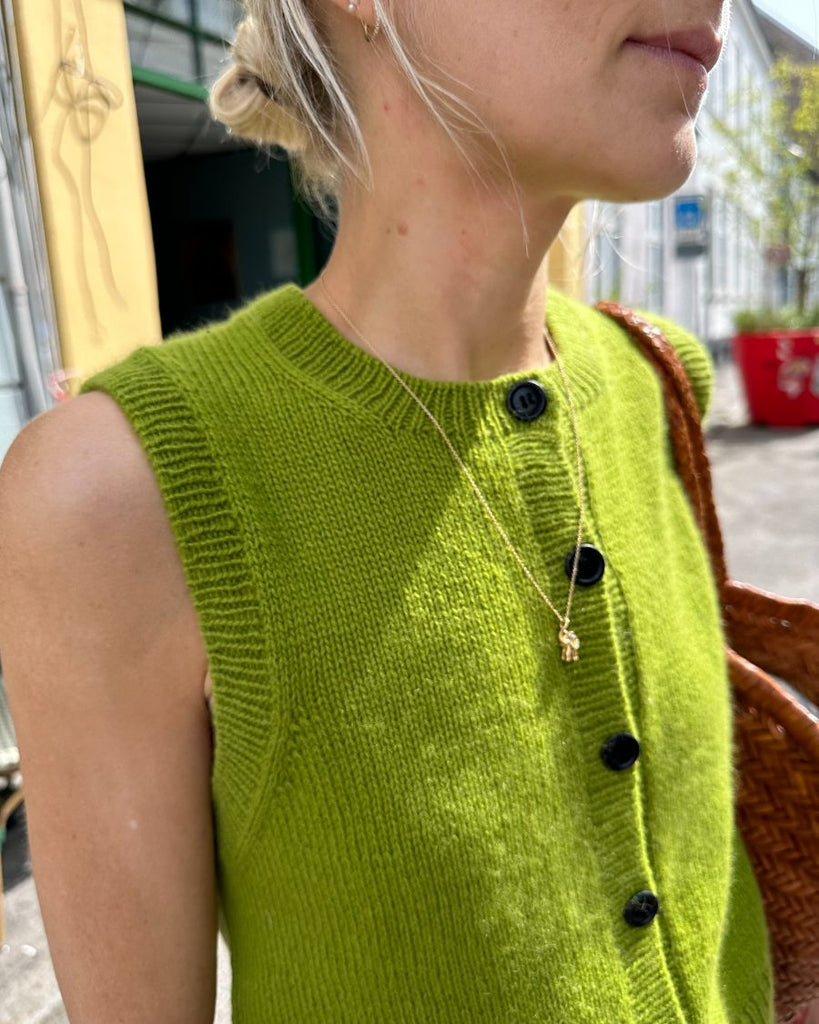 Kvinde med grøn Maggie vest og sorte galalit knapper