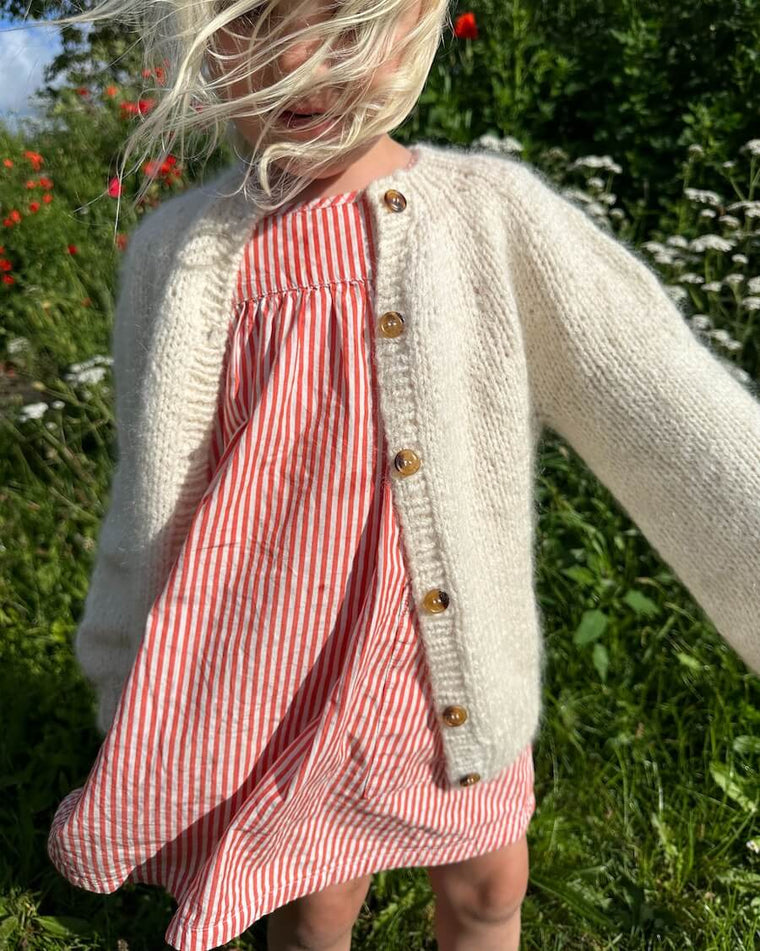 Barn iført lysegrøn Novice Cardigan Mini – Chunky Edition