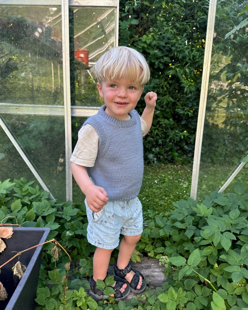 Barn iført blå Novice Slipover Junior
