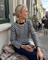 Kvinde iført hvid og blå Olga Blouse