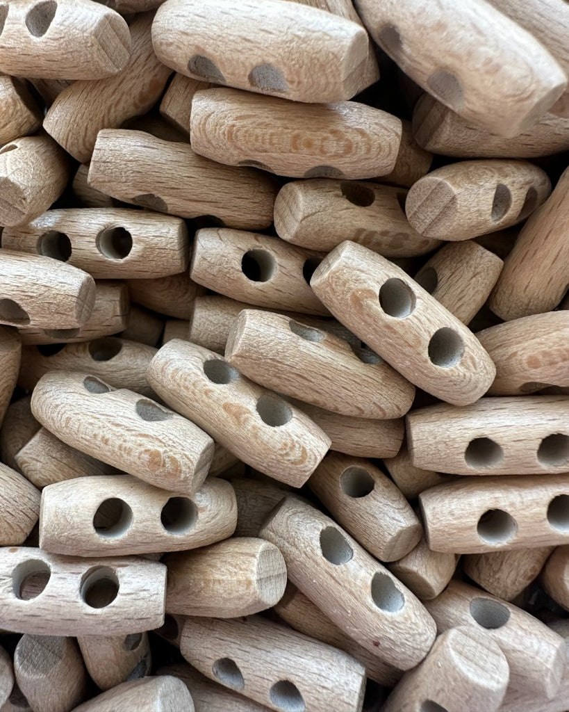 En bunke af små duffelknapper af træ på 25 mm