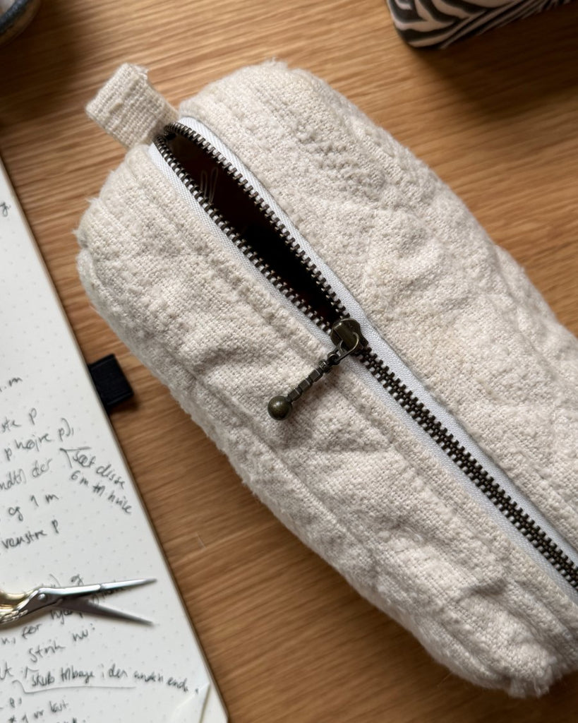 Knitter's Toll Clutch i farven Cloud på skrivebord