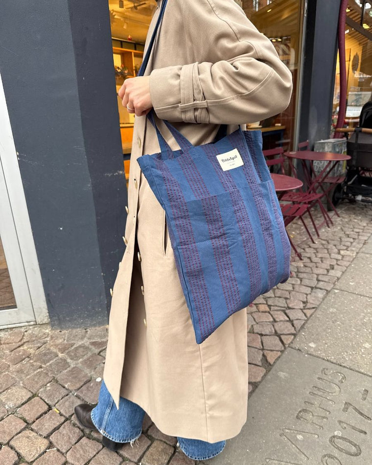 Kvinde med tote bag i farven Night Shadow over skulderen