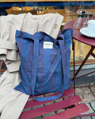 Tote Bag i farven Night Shadow stående på caféstol