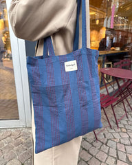 Kvinde med tote bag i farven Night Shadow over skulderen
