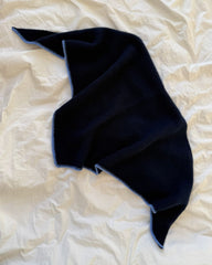 Blåt Uma Scarf liggende på sengetøj