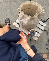Knitter's Project Bag stående på stol mens kvinde strikker