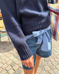 Kvinde iført blå Vega Sweater med fokus på ribkanterne