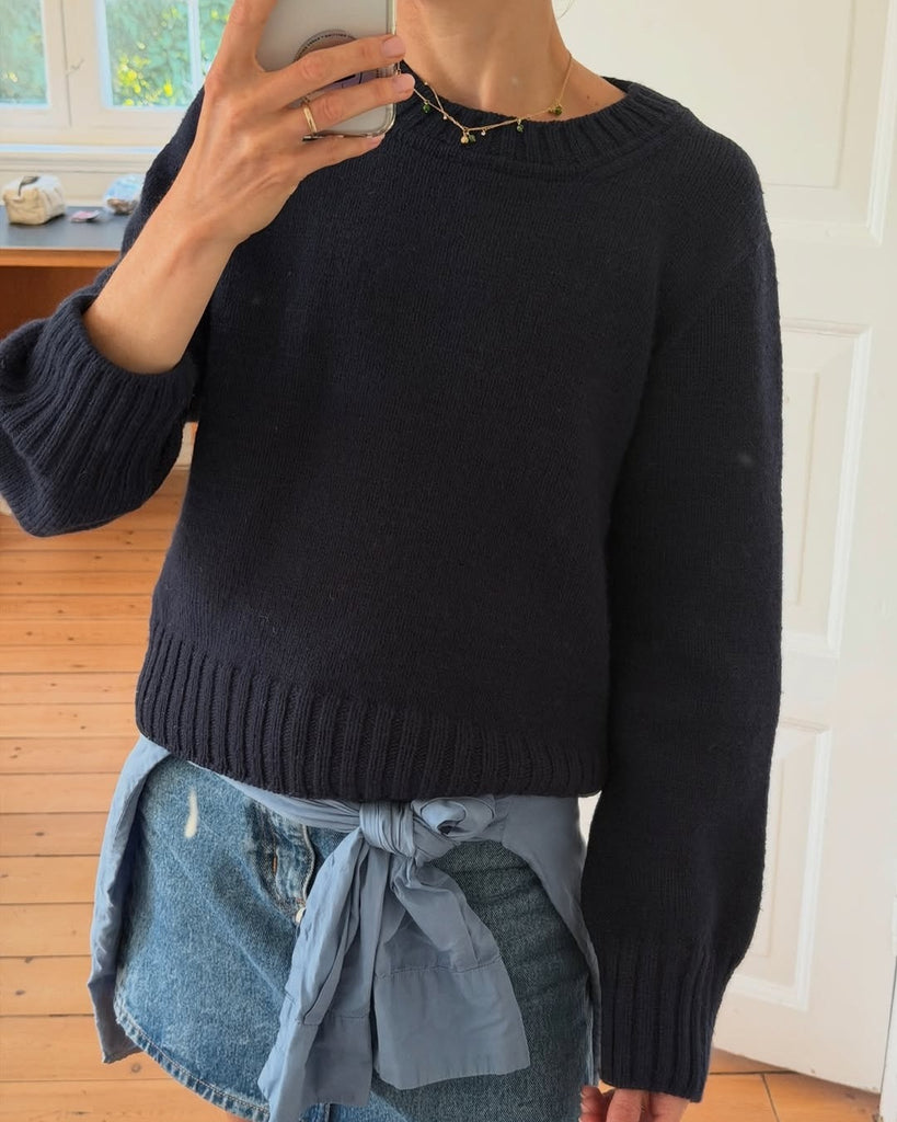 Kvinde iført blå Vega Sweater