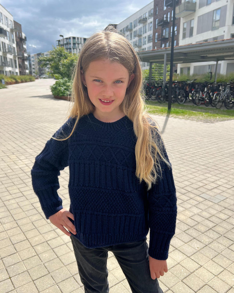 Barn iført mørkeblå Ingrid Sweater Junior 