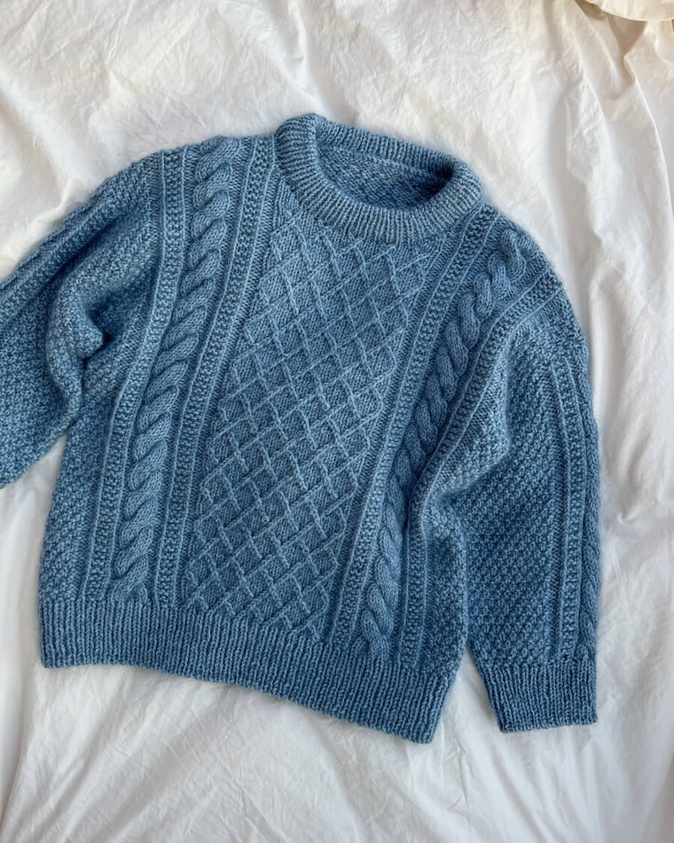Barn iført blå Moby Sweater Junior 