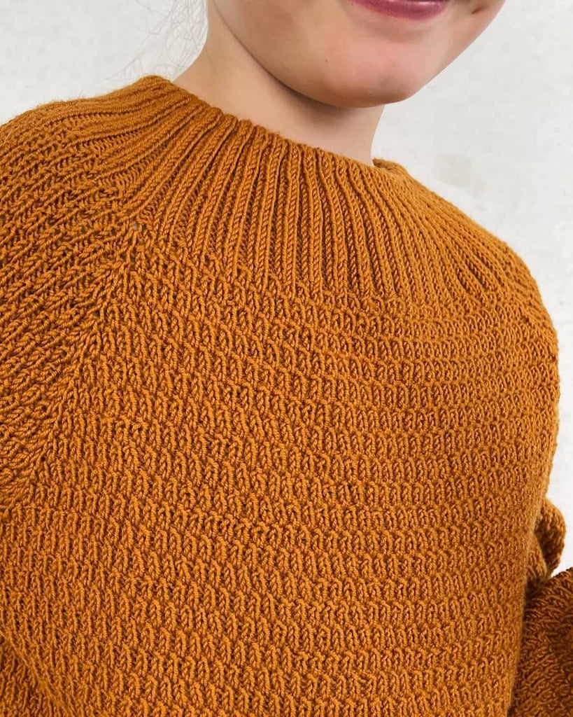 Closeup af pige i orange Alfreds Trøje Junior